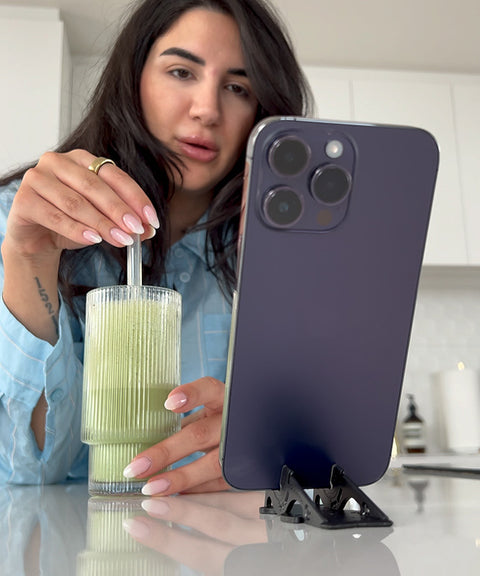 A woman on a facetime call, hands-free with her iPhone on a Pocket Tripod