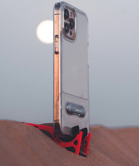 An iPhone held in a Pocket Tripod on the slope of a sand dune at an angle