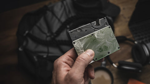 the pocket tripod in card format being inserted into a slim wallet