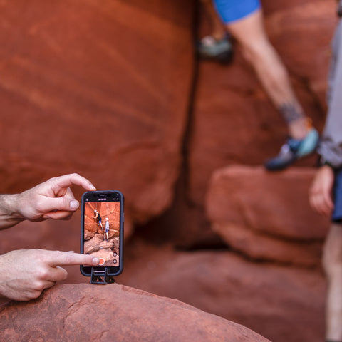 using an iphone on a pocket tripod to take a video of a group rock climbing in sedona arizona